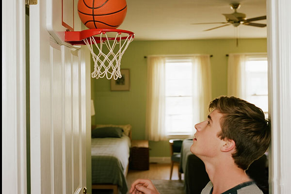 Apartment hallway shooting practice - player using silent basketball with mini hoop mounted on bedroom door frame