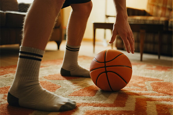 Quiet stationary dribbling drill - close-up of silent basketball being dribbled on apartment carpet with socks, no noise disturbance